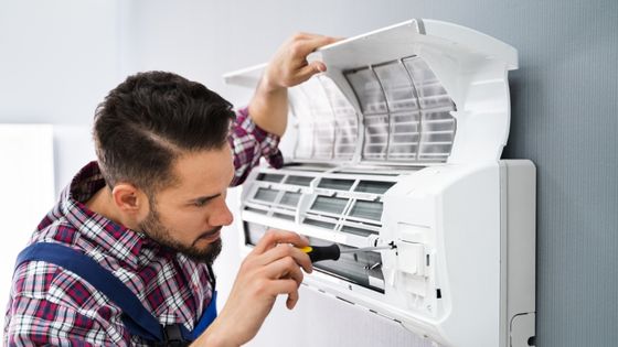 Cerfa mise en service climatisation - un installateur en train de poser une climatisation murale